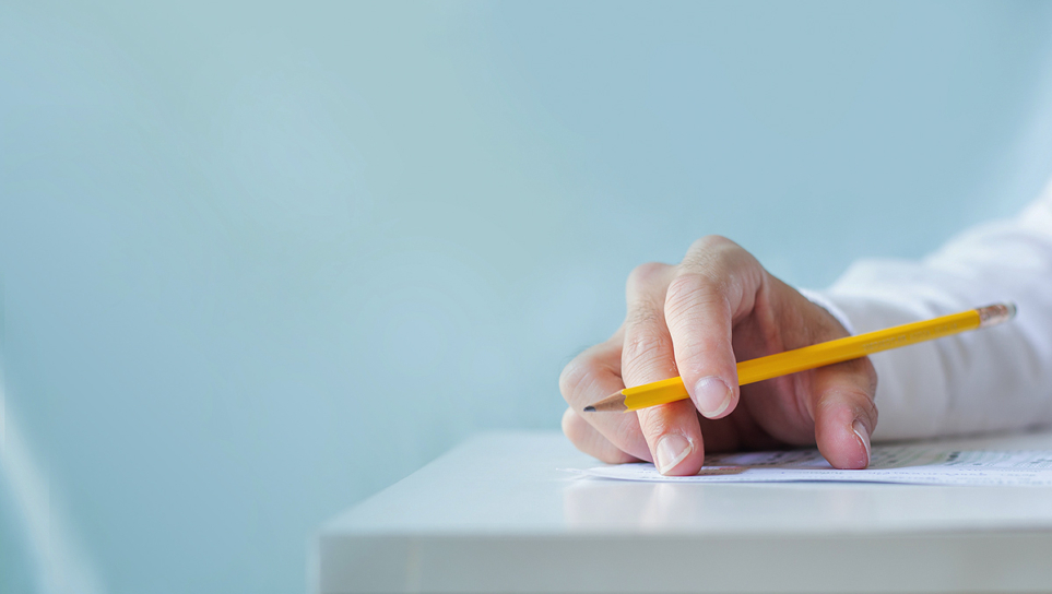 Fotografía de un profesor corrigiendo un examen, imagen en primer plano.